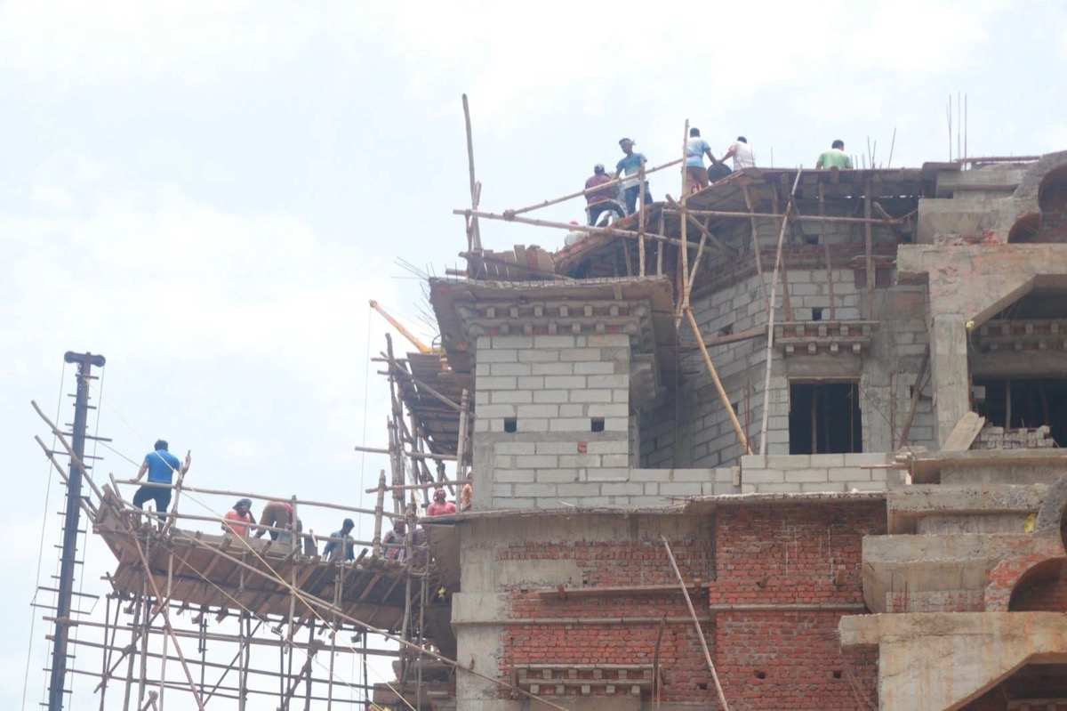 Builders on scaffolding during construction of Zangdok Palri