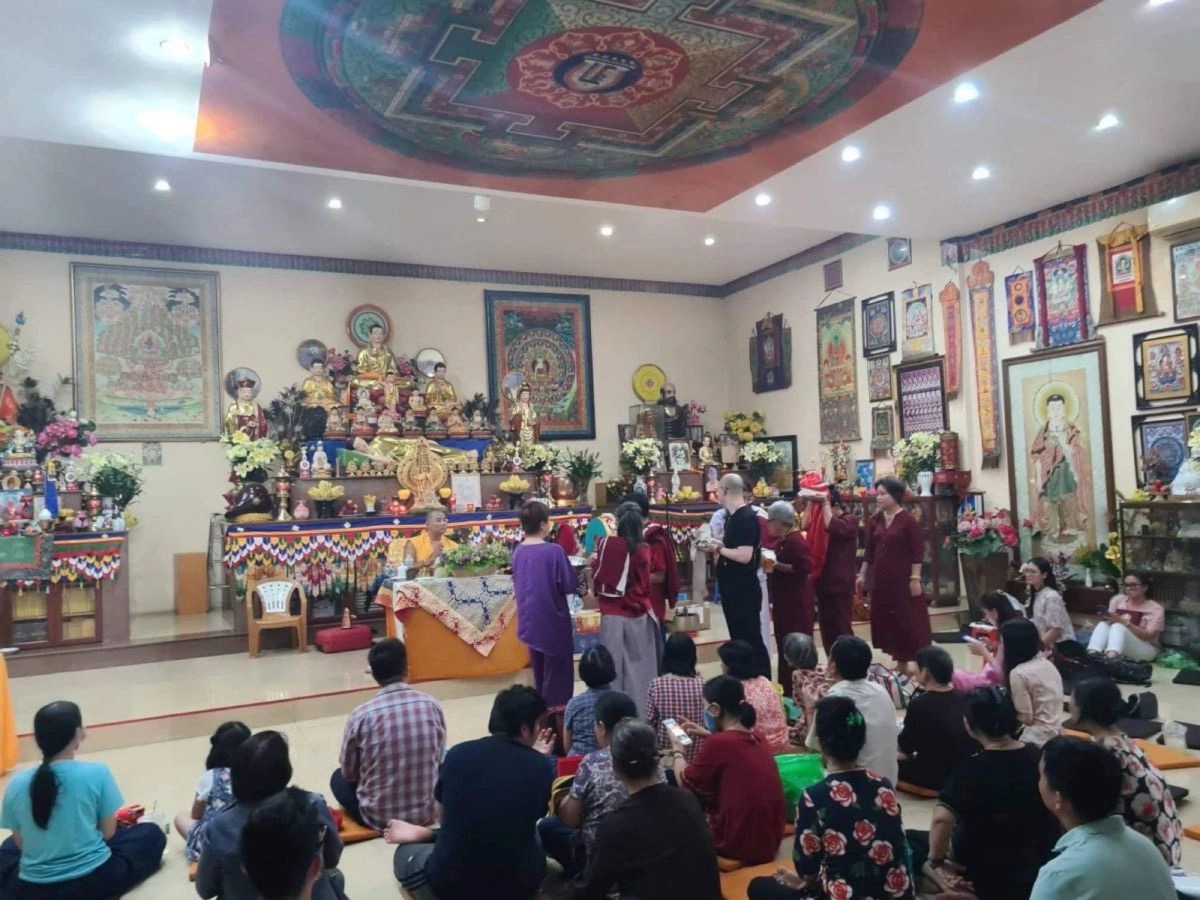 Practitioners seated in a colorful shrine hall during a teaching