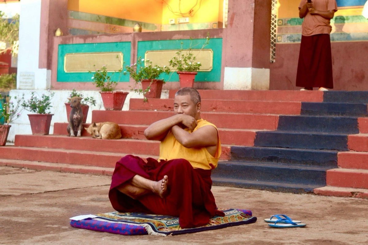 Lama Sonam Tashi Rinpoche practicing outdoors in front of the temple steps