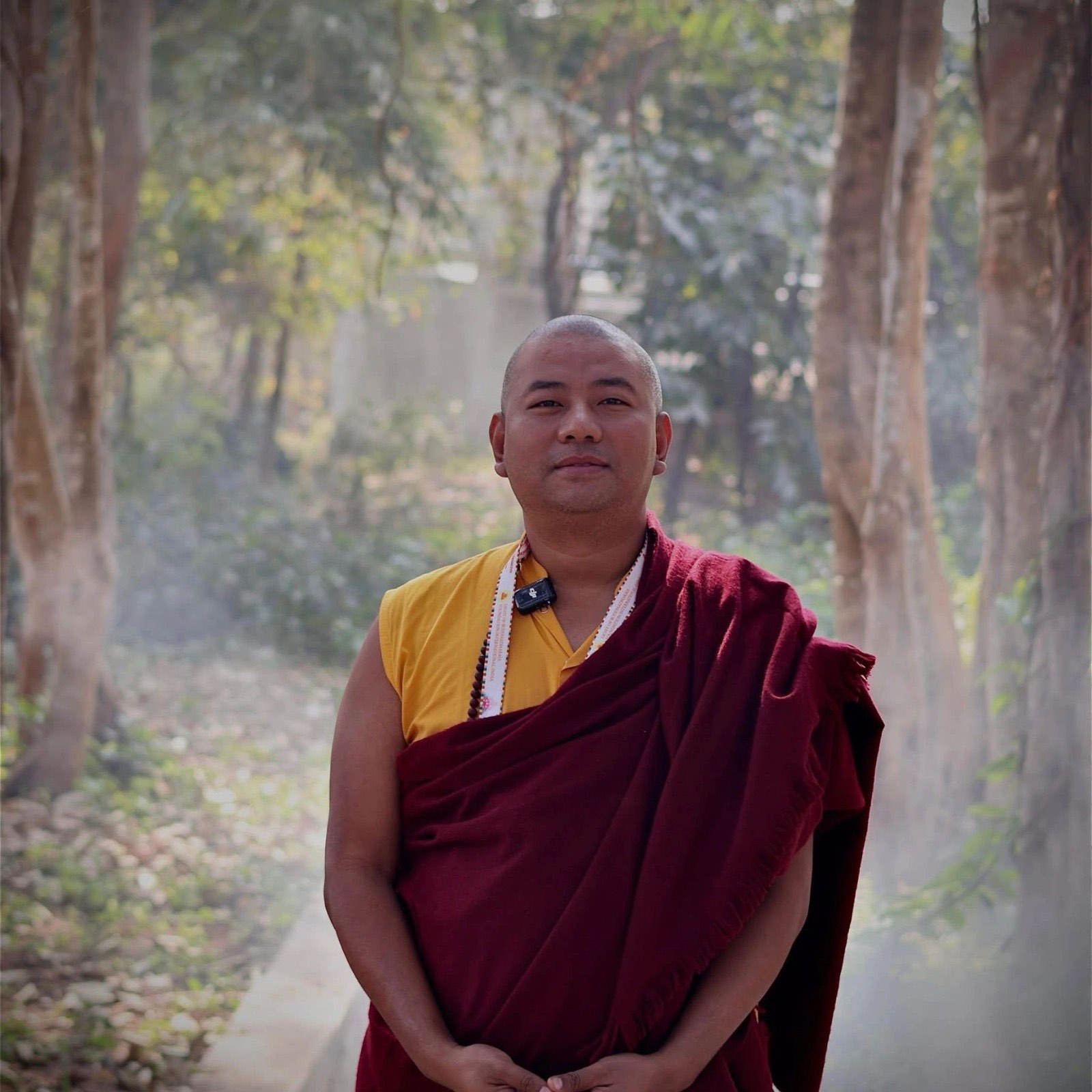 Lama Sonam Tashi Rinpoche standing in a misty forest