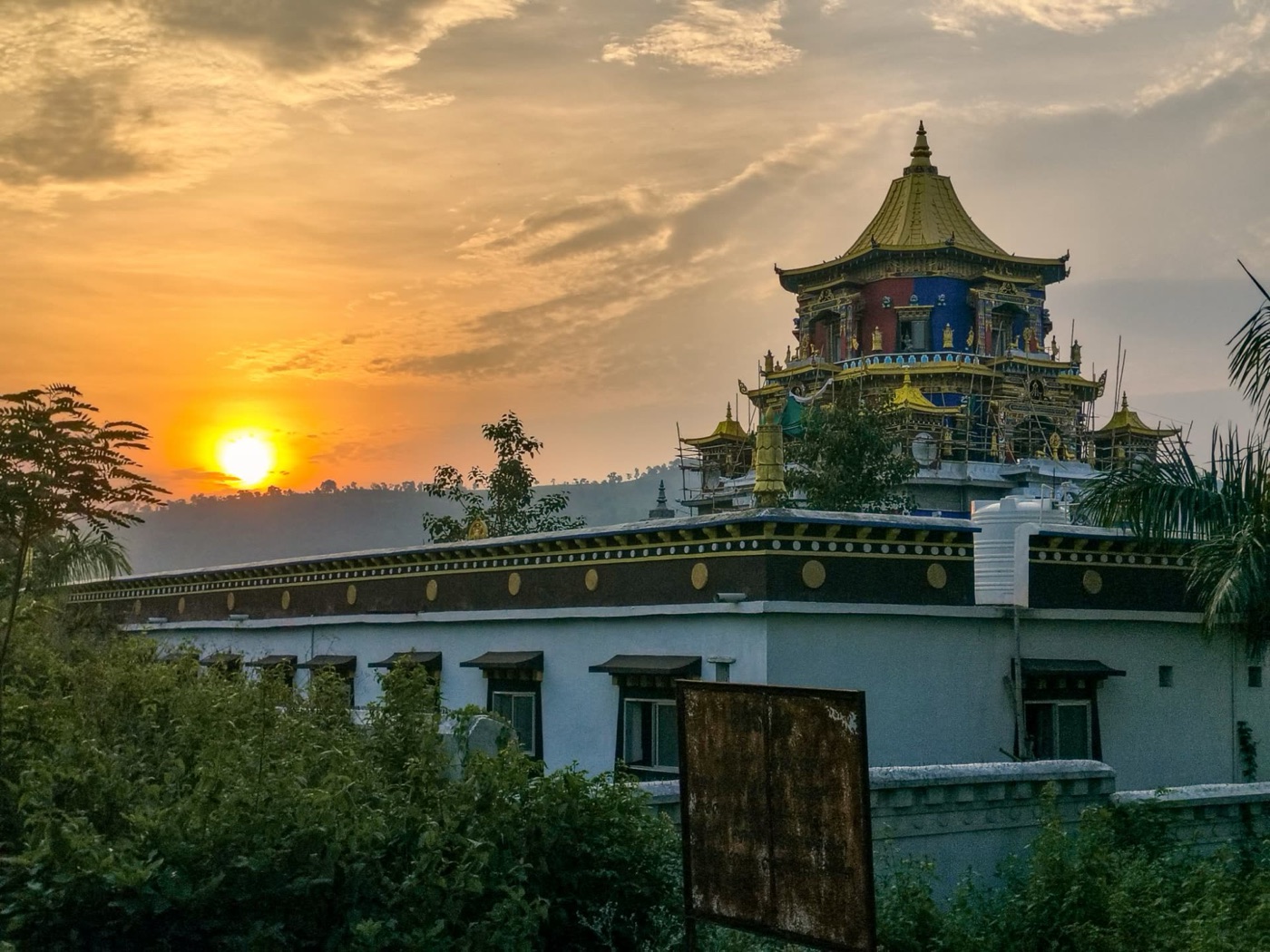 Zangdok Palri temple at sunset, its golden roof against the evening sky